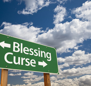 Blessing, Curse Green Road Sign Over Dramatic Blue Sky and Clouds.